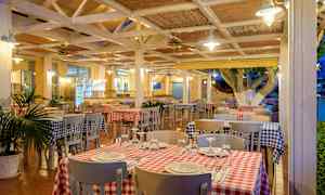 Ravintola, jossa ruudulliset pöytäliinat ja katetut pöydät. (Tekoälyn luoma teksti)