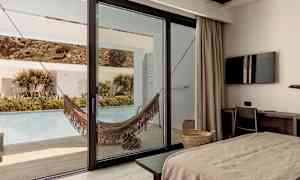 Hotellihuone näkymällä terassille, jossa riippumatto ja uima-allas. (Tekoälyn luoma teksti)