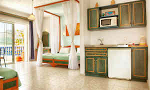 Valoisa hotellihuone, jossa on keittokomero ja sängyt vihreine vuodevaatteineen. (Tekoälyn luoma teksti)