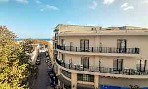 Näkymä kadulle rakennuksineen, taustalla näkyy sininen taivas. (Tekoälyn luoma teksti)