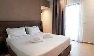 Hotellihuone, jossa on parivuode ja valkoiset lakanat, sekä sängylle asetetut taitetut pyyhkeet. (Tekoälyn luoma teksti)