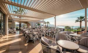 Ulkoterassi, jossa on mukavat istuimet ja näkymä merelle. (Tekoälyn luoma teksti)