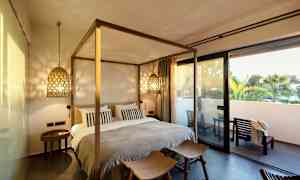 Makuuhuone, jossa sänky ja viihtyisä valaistus sekä terassi ulkopuolella. (Tekoälyn luoma teksti)