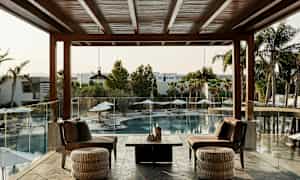 Terassi, jossa on istuimia, avautuu ulkouima-altaalle ja palmuihin. (Tekoälyn luoma teksti)