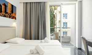 Hotellihuone, jossa on kaksi yhden hengen vuodetta, parveke näkymällä. (Tekoälyn luoma teksti)