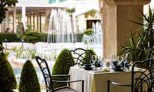 Ulkoilmaravintola, josta on näköala puutarhaan ja suihkulähteisiin. (Tekoälyn luoma teksti)