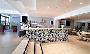 Hotellin vastaanotto, jossa yksityiskohtainen taso ja istumapaikkoja. (Tekoälyn luoma teksti)