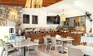 Aamiainen buffetissa valoisassa ravintolassa, pöydät katettuina. (Tekoälyn luoma teksti)