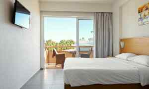 Hotellihuone, jossa parivuode ja parveke istuinpaikoilla. (Tekoälyn luoma teksti)