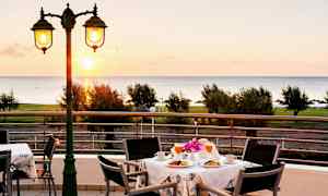 Näkymä aamiaisella varustetusta pöydästä terassilla, taustalla meri. (Tekoälyn luoma teksti)