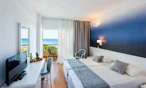 Hotellihuone, jossa kaksi sänkyä ja parveke merinäköalalla. (Tekoälyn luoma teksti)