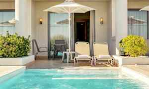 Yksityinen terassi aurinkotuoleilla, aurinkovarjolla ja pienellä uima-altaalla. (Tekoälyn luoma teksti)