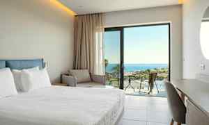 Hotellihuone, jossa on sänky, sohva ja näkymä merelle. (Tekoälyn luoma teksti)