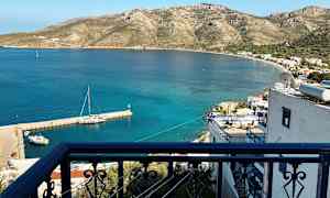 Parvekekaide, josta on näkymä pienelle satamalle ja rannikkoalueelle vuorien kera. (Tekoälyn luoma teksti)