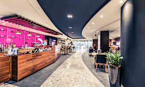 Moderni kahvilasisustus puisilla yksityiskohdilla ja värikkäillä yksityiskohdilla. (Tekoälyn luoma teksti)