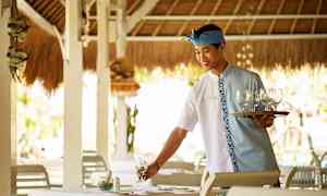 Tarjoilija, jolla on tarjotin ja laseja, valmistaa pöytää ravintolassa. (Tekoälyn luoma teksti)