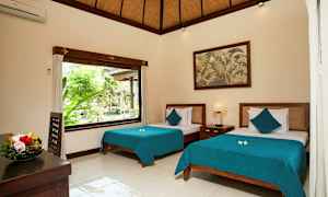 Vaaleasti ja tyylikkäästi sisustettu makuuhuone, jossa on kaksi vuodetta sinisillä päiväpeitteillä. Iso ikkuna päästää sisään luonnonvaloa ja avautuu vehreään ulkoilmaan. Pöydällä on hedelmävati, ja seinällä riippuu maalaus. (Tekoälyn luoma teksti)