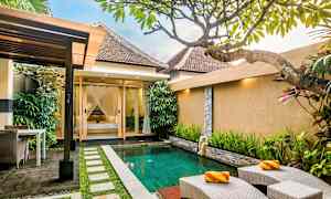 Terassi, jolla on pieni uima-allas, ympärillä kasvillisuutta ja taustalla talo. (Tekoälyn luoma teksti)