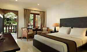 Hotellihuone, jossa on parivuode, istuinryhmä ja ikkuna vihreään maisemaan. (Tekoälyn luoma teksti)