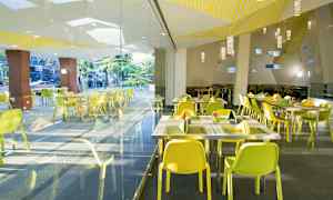 Kuva modernista ravintolasta, jossa on keltaiset tuolit ja lasiseinät. (Tekoälyn luoma teksti)