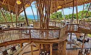 Rakennus, jossa bamburakenne ja huonekalut, näkymä vihreisiin alueisiin ja merelle. (Tekoälyn luoma teksti)