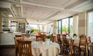 Ravintola, jossa on katettuja pöytiä ja näkymä kupolirakennukseen. (Tekoälyn luoma teksti)