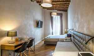 Hotellihuone, jossa on kaksi sänkyä, työpöytä ja taulutelevisio. (Tekoälyn luoma teksti)