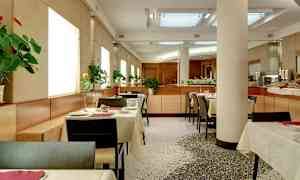 Moderni ravintola, jossa on katettuja pöytiä ja kukkia jokaisella pöydällä. (Tekoälyn luoma teksti)