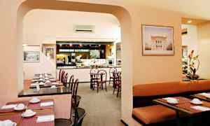 Ravintola-alue, jossa on pöytiä ja tuoleja sekä buffet-tarjoilualue. (Tekoälyn luoma teksti)