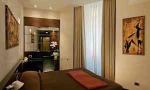 Hotellihuone, jossa on moderni sisustus, ikkuna luonnonvalolla, peili ja työpöytä tuolin kanssa. (Tekoälyn luoma teksti)