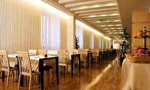 Kuva ravintolasta, jossa pöydät ja tuolit, puulattia ja hedelmiä pöydällä. (Tekoälyn luoma teksti)