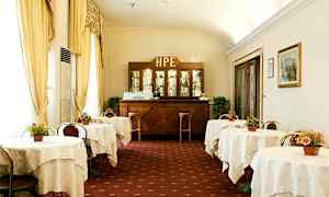 Kuva klassisesta hotellikahvilasta, jossa on katettuja pöytiä ja puinen baari taustalla. (Tekoälyn luoma teksti)