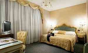 Hotellihuone, jossa on parivuode, kirjoituspöytä tuoleineen ja televisio. (Tekoälyn luoma teksti)