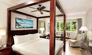 Hotellihuone, jossa on katossänky, istuinryhmä ja iso ikkuna. (Tekoälyn luoma teksti)