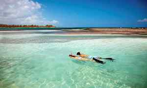Kaksi henkilöä snorklaa turkoosissa vedessä. (Tekoälyn luoma teksti)