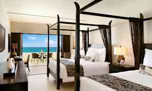 Hotellihuone, jossa kaksi pylvässänkyä ja näkymä merelle parvekkeelta. (Tekoälyn luoma teksti)