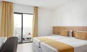 Hotellihuone, jossa on kaksi yhden hengen vuodetta ja parveke. (Tekoälyn luoma teksti)