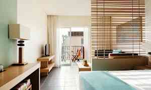 Moderni hotellihuone, näkymä parvekkeelle, jossa on ulkokalusteet. (Tekoälyn luoma teksti)