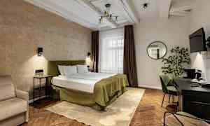 Hotellihuone, jossa on parisänky, yöpöydät, työpöytä ja seinällä peili. (Tekoälyn luoma teksti)