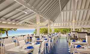 Ulkoterassi, jossa valkoiset kalusteet ja merinäköala. (Tekoälyn luoma teksti)