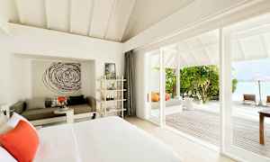 Valoisa hotellihuone modernilla sisustuksella ja merinäköalalla. (Tekoälyn luoma teksti)