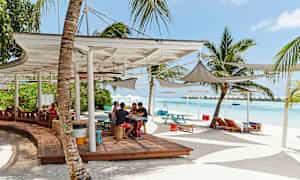 Ranta istumapaikoilla, aurinkovarjoilla ja palmuilla. (Tekoälyn luoma teksti)