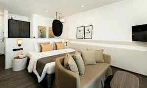 Moderni hotellihuone, jossa makuupaikka ja oleskelutila. (Tekoälyn luoma teksti)