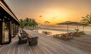 Puinen terassi infinity-altaan ja meren äärellä iltataivaan alla. (Tekoälyn luoma teksti)