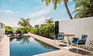 Yksityinen uima-allas terassilla, jossa aurinkotuoleja ja merinäköala. (Tekoälyn luoma teksti)