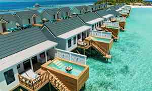 Paalurakenteisia bungaloweja, joissa on yksityiset pienet altaat kirkkaan turkoosin veden yllä. (Tekoälyn luoma teksti)