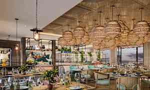 Tyylikkään ravintolan sisustus, jossa on koristeelliset valaisimet katossa ja tyylikkäät kalusteet. (Tekoälyn luoma teksti)