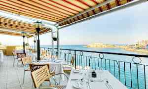 Pöytä ulkoterassilla markiisin alla, näköala merelle. (Tekoälyn luoma teksti)