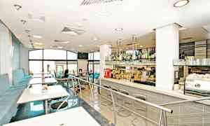 Nykyaikainen kahvilan sisustus istumapaikoilla ja baaritiskillä. (Tekoälyn luoma teksti)