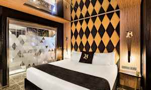 Hotellihuone, jossa moderni sisustus, parivuode ja koristeellinen seinämalli. (Tekoälyn luoma teksti)